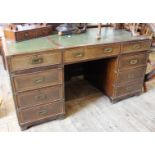 A 1920's mahogany Campaign style pedestal desk with green leather inset top