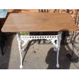 A cast iron painted table with stained teak top