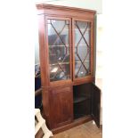 A Georgian mahogany two part corner cabinet with astragal glazed upper door and painted interior on