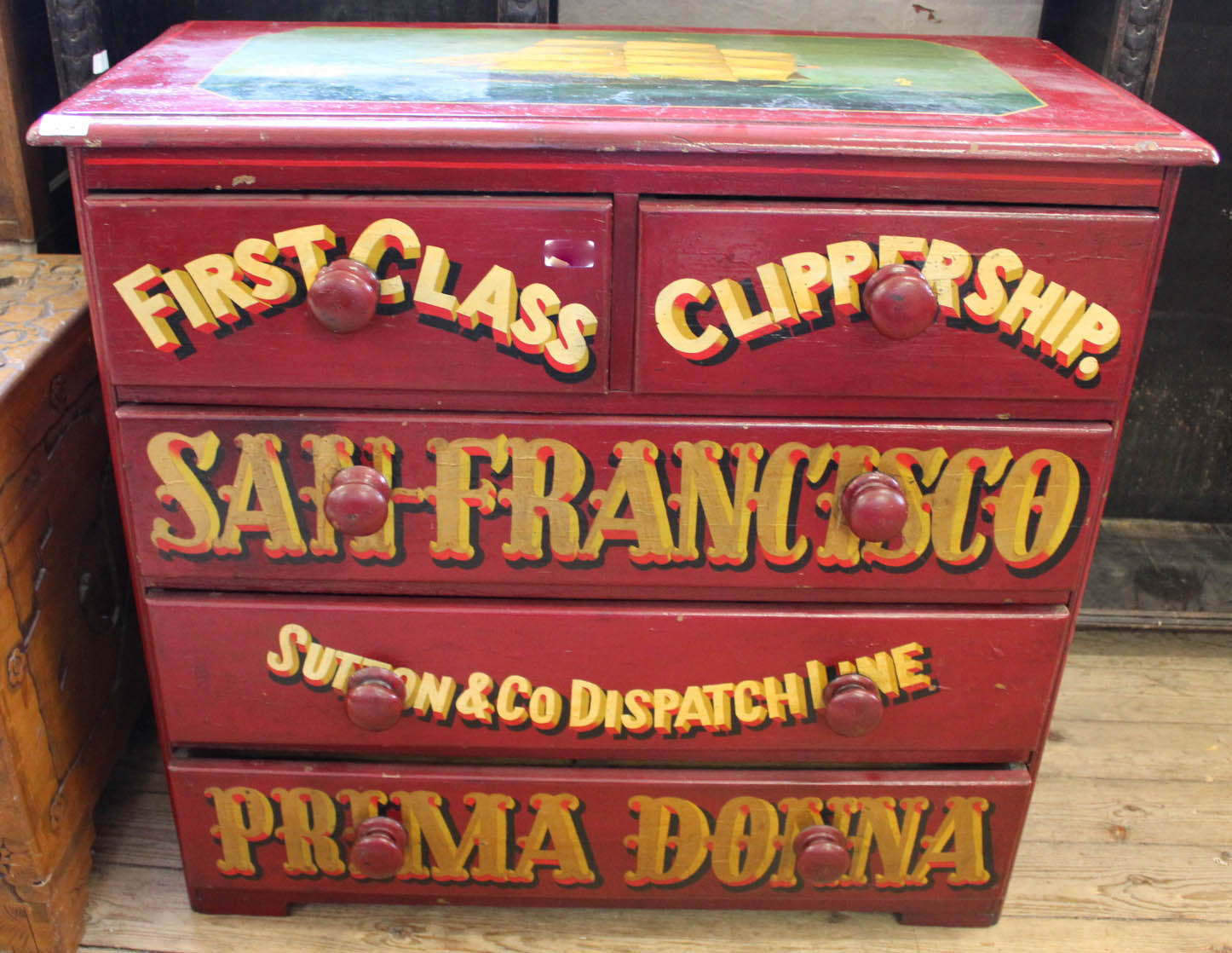 A decorated chest of drawers with sailing ship painting on the top