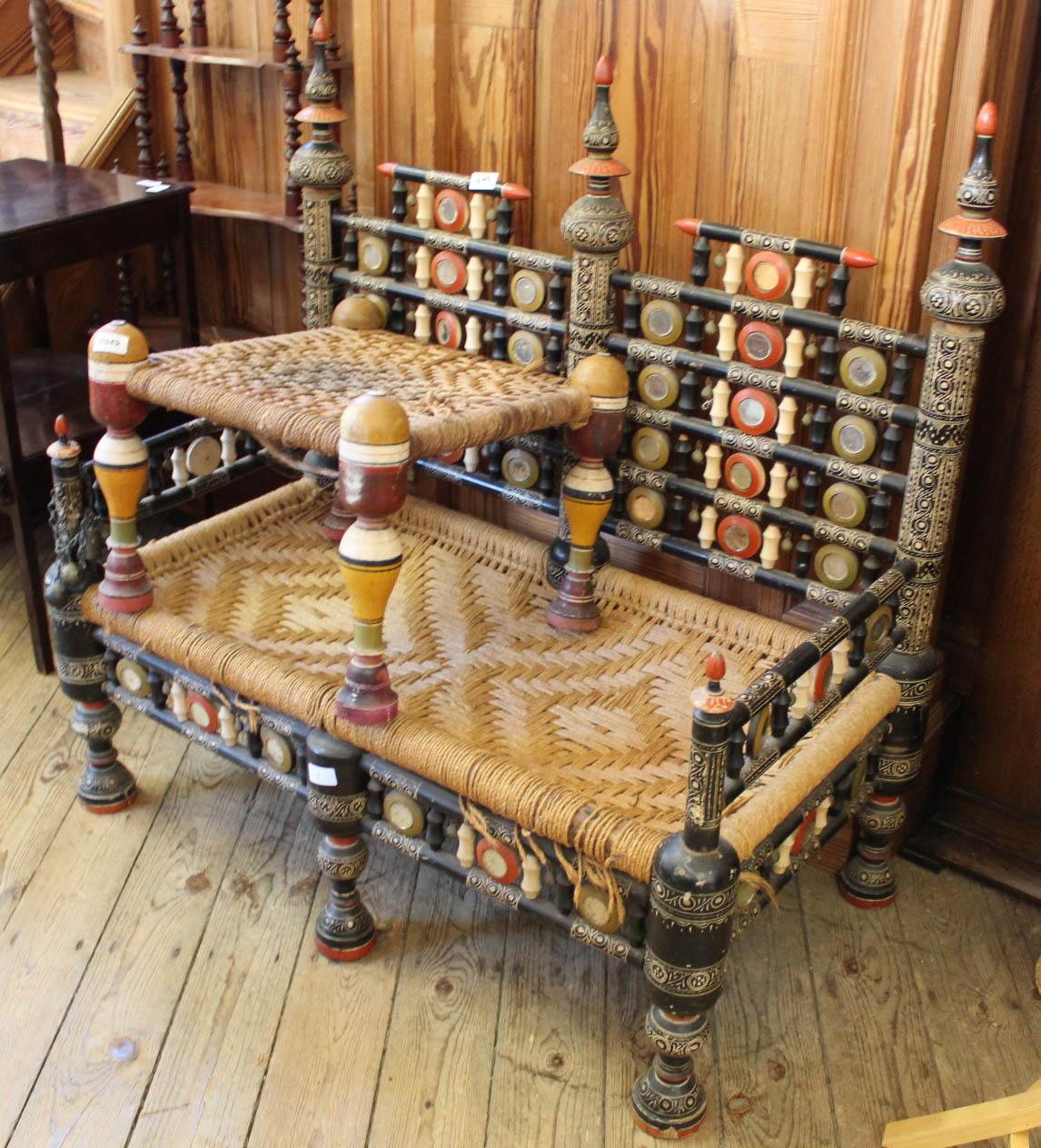 A highly decorated Moroccan two seater rush seat chair and foot stool with painted details and