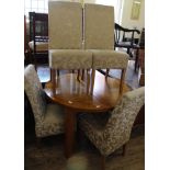 A modern oak extending dining table with four upholstered dining chairs