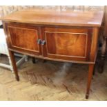 An Edwardian mahogany bow fronted two door cupboard on square tapered legs