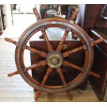 A large vintage oak and brass ship's wheel