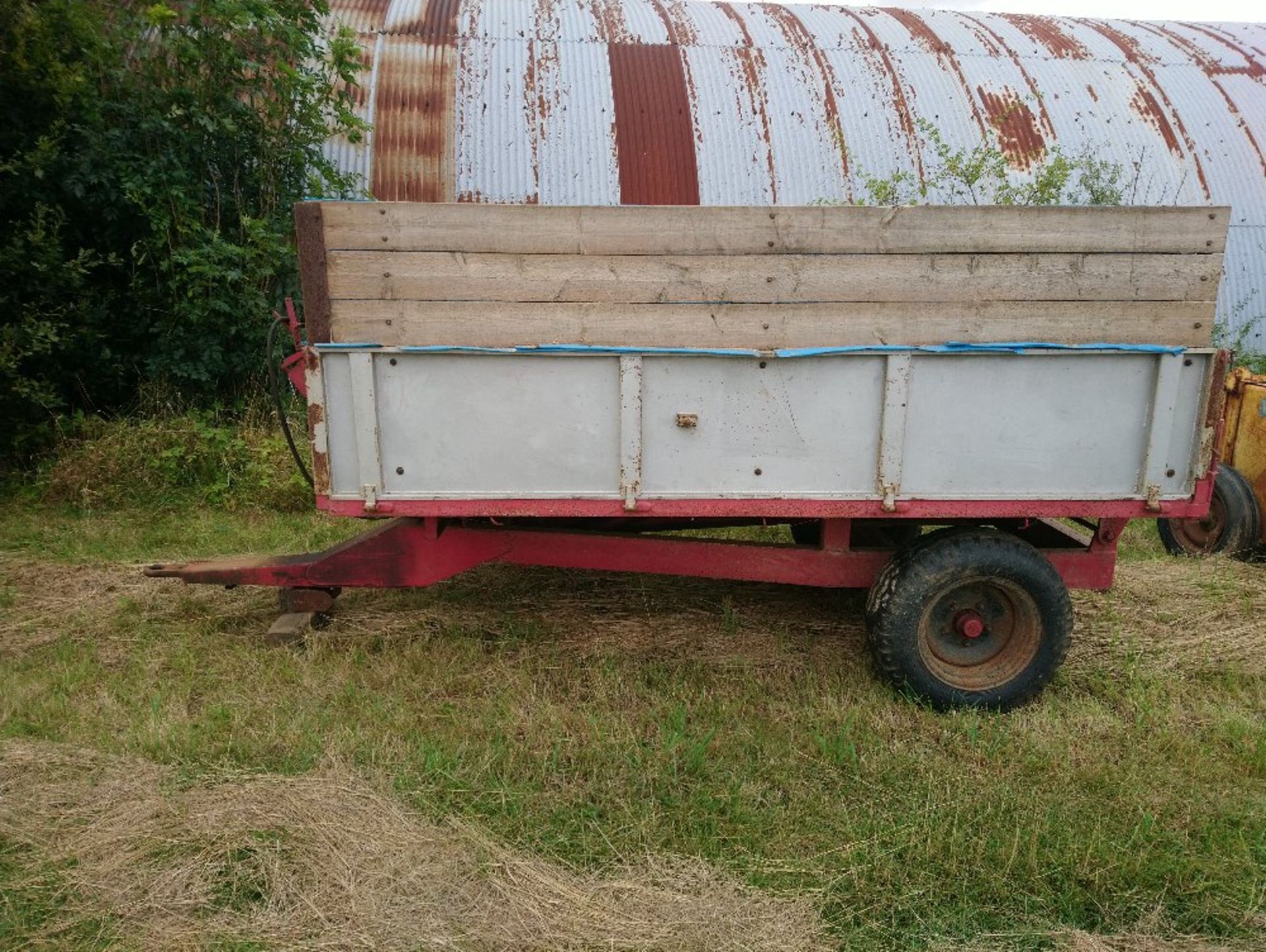 2 wheel hydraulic tipping trailer with metal sides below wooden extensions
