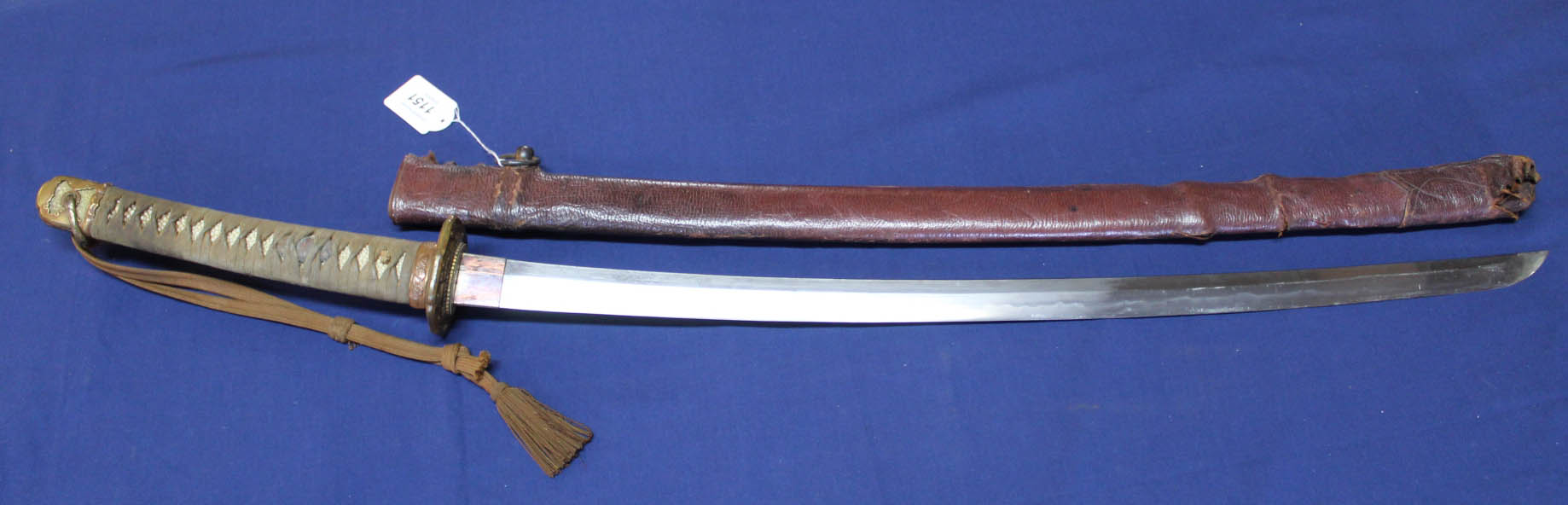 A Japanese shin gunto with signed tang, leather covered saya and knot,
