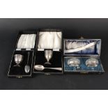 A boxed egg cup and spoon, a boxed egg cup and non matching spoon,