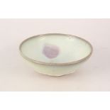 A Chinese pottery bowl with thickly applied light green glaze,