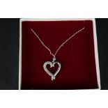 A 10ct white gold heart shaped pendant set with diamonds on 10ct white gold chain