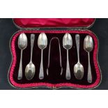 A boxed set of six silver teaspoons and sugar tongs with engraved decoration
