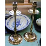 A pair of Edwardian brass candlesticks with drip trays, slender stems and circular bases,