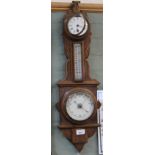 A carved oak aneroid barometer/clock