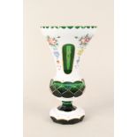 A Bohemian green glass vase with white overlay painted with flowers,