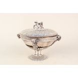 A white metal covered bowl on stand with winged sphinx handle and rams head decoration