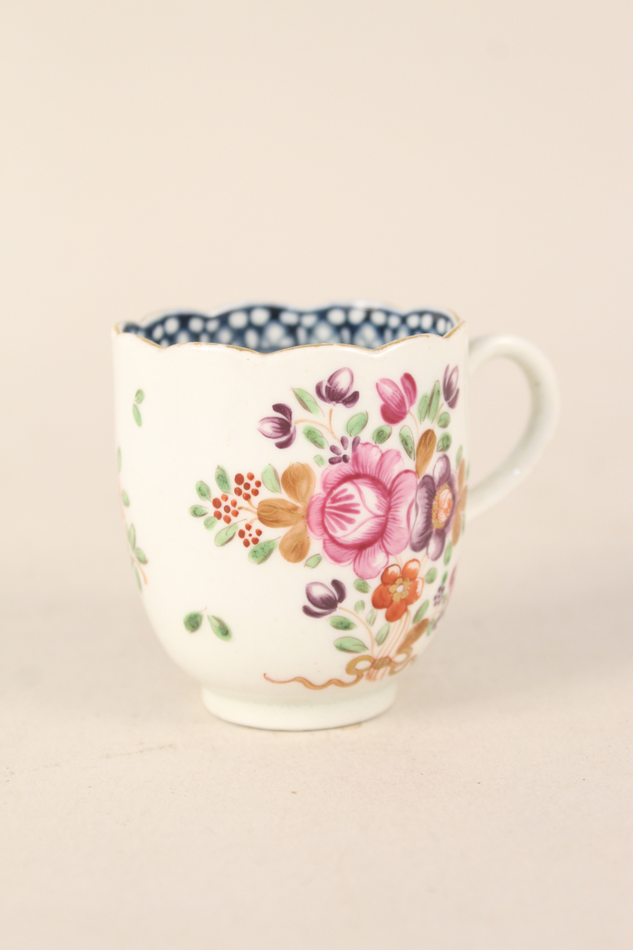 A Worcester cup with floral decoration, fluted top rim and blue internal border,