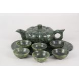 A Chinese spinach jade wine pot of compressed shape with six bowls and shaped tray