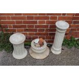 Two weathered marble columns and a pot