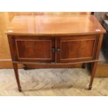 An Edwardian mahogany bow fronted two door cupboard on square tapered legs