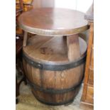 An unusual two tier table made from a converted whiskey barrel with copper top