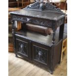 A 1920's carved oak buffet stand with green man style carving and two door cupboard below single