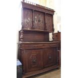 A 1920's carved oak two part cupboard