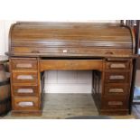 A 1920's roll top pedestal desk with nine drawers