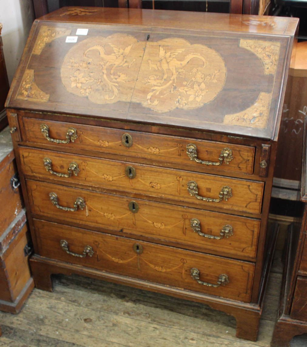 A profusely inlaid early 19th Century four drawer bureau with inlaid decoration to the interior