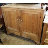 A Victorian stripped pine two door cupboard with two drawers