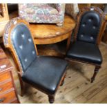 A pair of Victorian carved oak black leather upholstered dining chairs