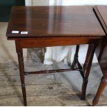 An Edwardian mahogany games table with swivel top and storage compartment below