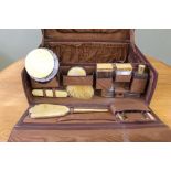 A leather vanity case with contents including bottles, brushes,