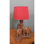 A 1960's carved wooden table lamp with three elephants to base