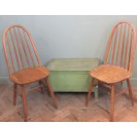 A pair of hoop back Ercol Priory range stools and a green painted trunk