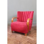 A 1930's red upholstered armchair with curved beech bentwood arms