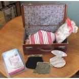 A vintage suitcase and contents including wigs, a mesh handbag,