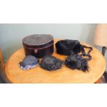 A vintage black hat box containing Victorian lady's hats and a muff