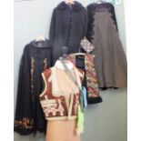 A collection of vintage clothing including a velvet cap, heavily embroidered waistcoat,