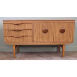 A mid-century sideboard with three drawers and two door cupboard, with two round handles,