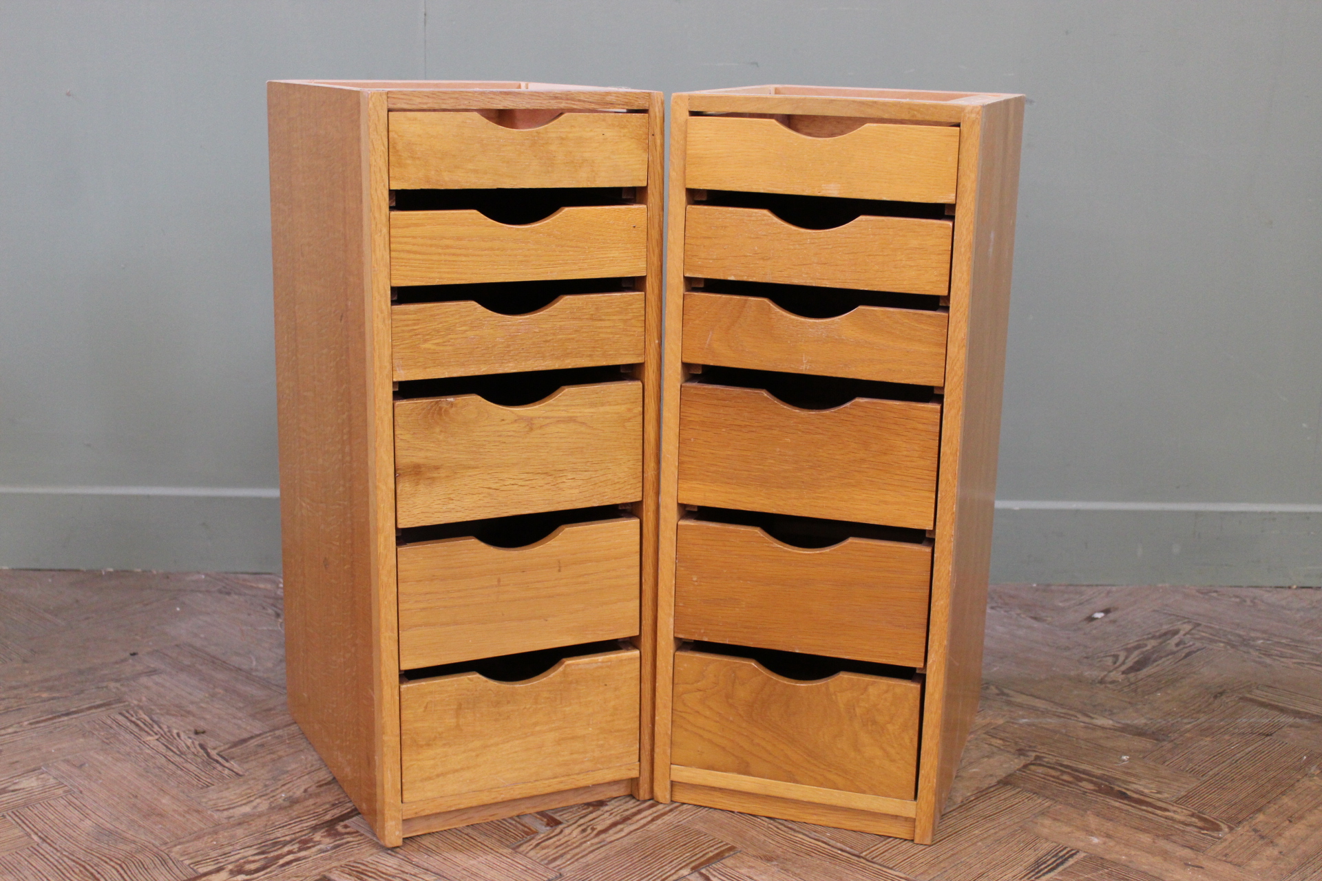 A pair of narrow teak utility chests of six drawers