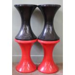 A pair red plastic stools and a pair of black ones in the same style