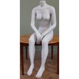 A vintage mannequin in the form of a headless seated woman