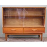 A 1970's glazed teak bookcase on tapered legs with two drawers