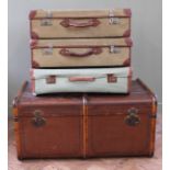 A large steamer trunk and three canvas and leather suitcases