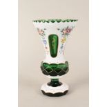 A Bohemian green glass vase with white overlay painted with flowers,