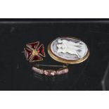 An 18ct gold shell cameo brooch and two yellow metal stone set brooches