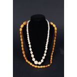 An amber coloured bead necklace and ivory necklace