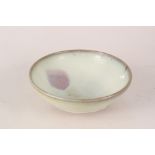 A Chinese pottery bowl with thickly applied light green glaze,