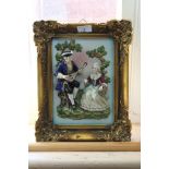 A framed porcelain relief panel of a man serenading a lady