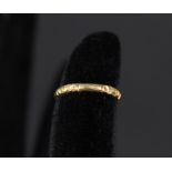 A Victorian 18ct gold band ring with engraved decoration,