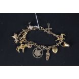 A 9ct gold charm bracelet hung with multiple charms including animal themed,